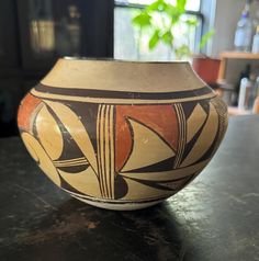 a vase sitting on top of a table next to a window