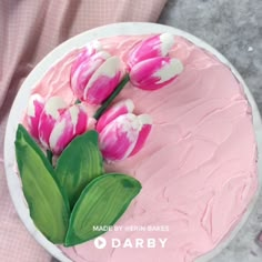 a cake decorated with pink and white tulips on top of a marble table