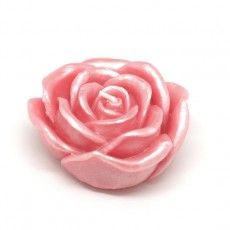 a close up of a pink rose shaped candle on a white background with clipping for text