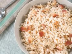 a white bowl filled with rice and toppings on top of a blue table cloth