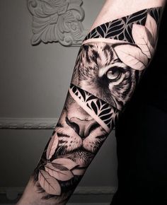 a man's arm with a tiger and flowers tattoo on the left side of his arm