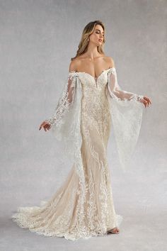 a woman in an off the shoulder wedding dress with long sleeves and sheer lace detailing