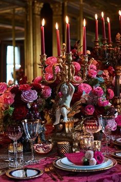 the table is set with pink flowers and candles