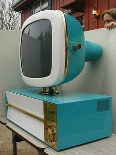 a blue and white computer sitting on top of a wooden table next to a building