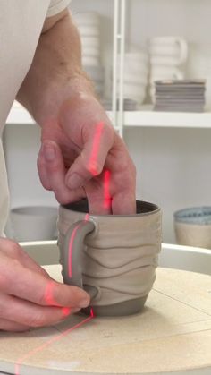 a person is making a cup with red light coming from it