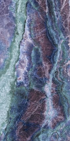 an aerial view of the earth's surface, with blue and green paint on it