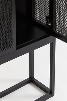 a black cabinet with metal mesh doors on the front and side, against a white background