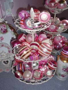 three tiered trays filled with pink and white ornaments