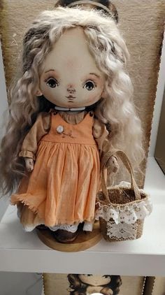 a doll with long blonde hair sitting on top of a shelf next to a basket