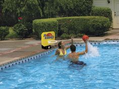 two people playing with a ball in a swimming pool