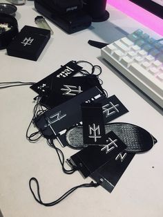 some black tags sitting on top of a white desk next to a keyboard and mouse