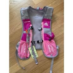 a pink life jacket sitting on top of a wooden floor