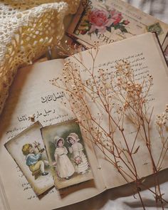 an open book sitting on top of a bed next to some flowers and bookshelves