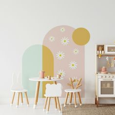 a child's play room with white furniture and flowers painted on the wall behind it