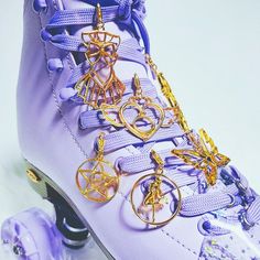 the roller skate is decorated with gold chains and charms on it's laces