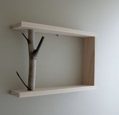 two wooden shelves with one tree on each shelf and the other branch in between them