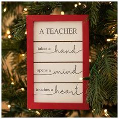 a teacher takes a hand opens a mind touches a heart ornament hanging on a christmas tree