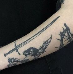 a man's arm with tattoos on it and two swords in the middle of his arm