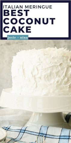 a white cake sitting on top of a table next to a plate with a fork