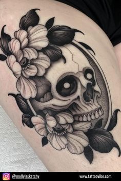 a woman's thigh with a skull and flowers on it