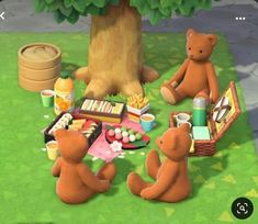 two brown teddy bears sitting at a picnic table with food and drinks on the grass