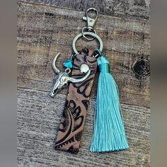 a keychain with a cow head and tassel hanging from it's side