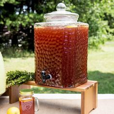 a jar filled with liquid sitting on top of a wooden table