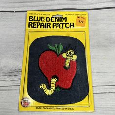 a patch with a red apple and caterpillars on it