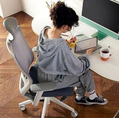 a woman sitting at a desk using a laptop computer