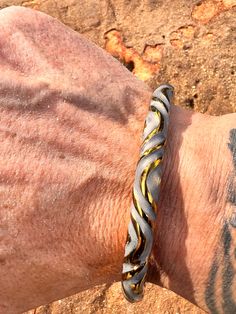 a man's arm with a black and yellow bracelet on it