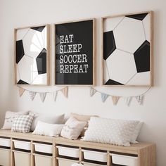 three framed pictures hang on the wall above a row of storage bins with pillows