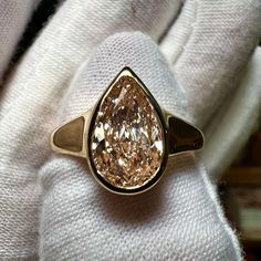 a close up of a gold ring with a fancy brown diamond in it's center