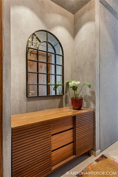 a wooden dresser sitting in front of a mirror