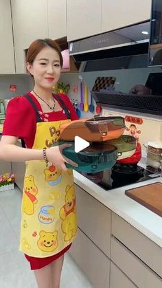 a woman in an apron holding a tray with food on it