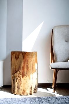 a wooden table sitting on top of a rug next to a chair