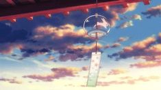 an anime scene with clouds and a wind chime hanging from the ceiling above it