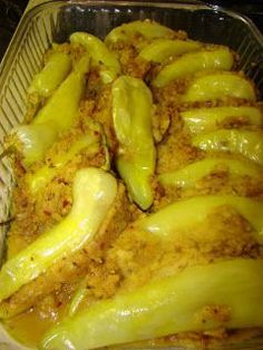 a casserole dish filled with yellow peppers and sauces on the top side