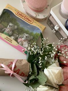 a bouquet of flowers sitting on top of a table next to a box of cake