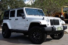 a white jeep is parked in the parking lot