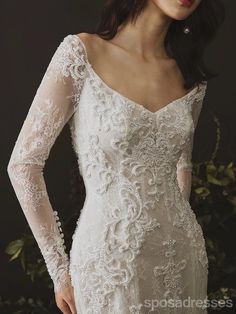 a woman wearing a wedding dress with long sleeves