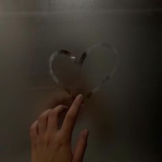 a person's finger pointing at a heart shaped object