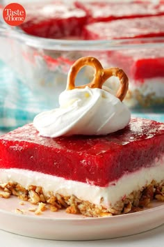 a piece of dessert with whipped cream and pretzels on top is sitting on a plate