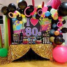 balloons and streamers decorate the backdrop for an 80's themed birthday party with gold sequins