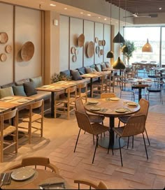 an empty restaurant with tables and chairs lined up against the wall, along with large windows