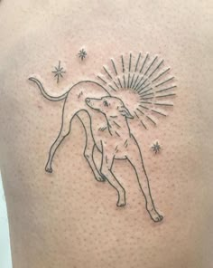 a tattoo on the back of a woman's shoulder with a dog and sunburst