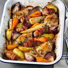 a casserole dish with chicken, potatoes and carrots