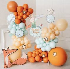 an assortment of balloons and decorations for a baby's first birthday party with animals