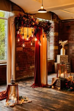 a room filled with lots of lights next to a wooden floor covered in curtains and flowers