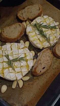 bread and cheese are arranged on a baking sheet with some rosemary sprigs in the middle