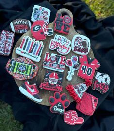 decorated cookies are arranged on a wooden platter in the shape of dogs and footballs